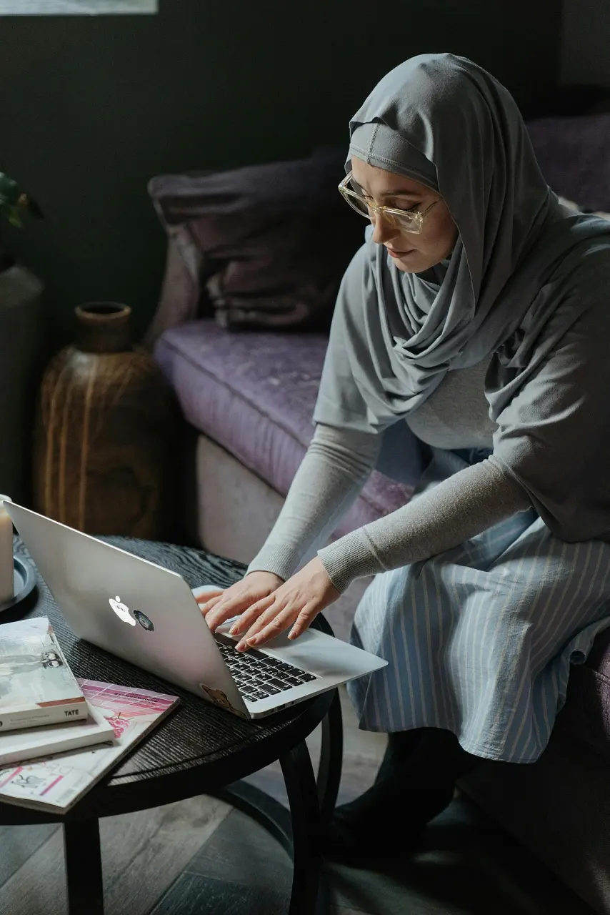 Woman using a laptop from a sofa at home